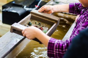 A young girl panning for gems at Two Rivers Mining Co.