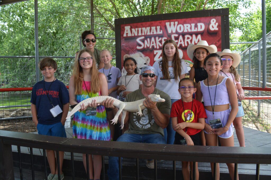 Deputy Director Jarrod Forthman with a group of field trip attendees and an albino alligator