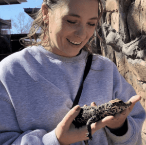 A zoo guest holding one of our baby dwarf crocodiles.